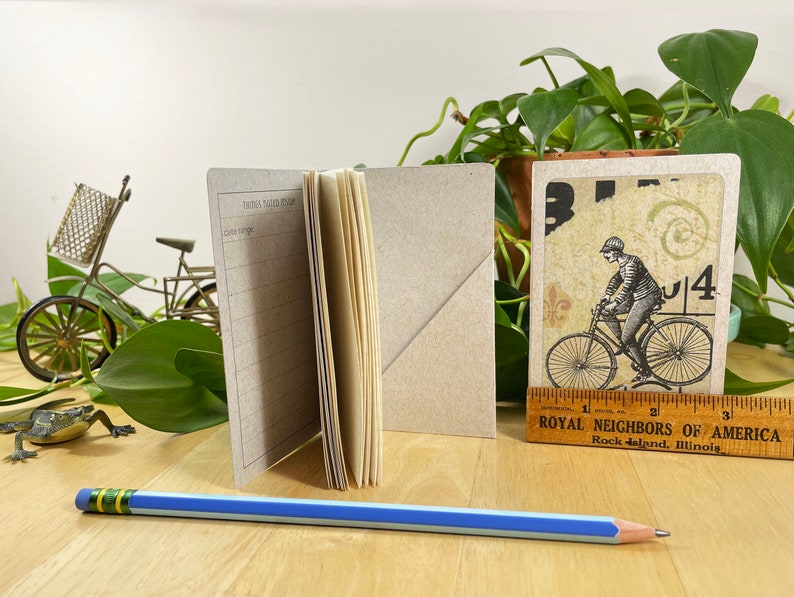 Mini cahier avec collage de bicyclettes sur la couverture, poche arrière et 48 pages légèrement quadrillées. Le tout recyclé. Cousu à la main avec du fil de lin. image 8