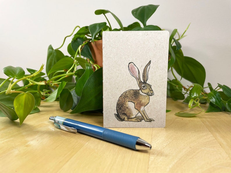 Mini notebook with jackrabbit on cover, pocket in back, and 48 lightly gridded pages. All recycled. Hand sewn with linen thread. image 1