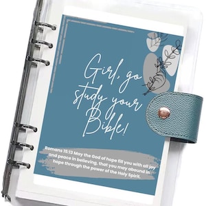 May include: A planner insert with the text "Girl, go study your Bible!" in white script on a teal background. The insert includes a Bible verse and decorative floral elements. The planner has a teal closure.