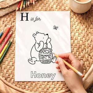 May include: Black and white illustration of Winnie the Pooh with a honey pot labeled "Hunny". The image is part of an alphabet series, with the letter "H" and the word "Honey" displayed. A butterfly is also present.