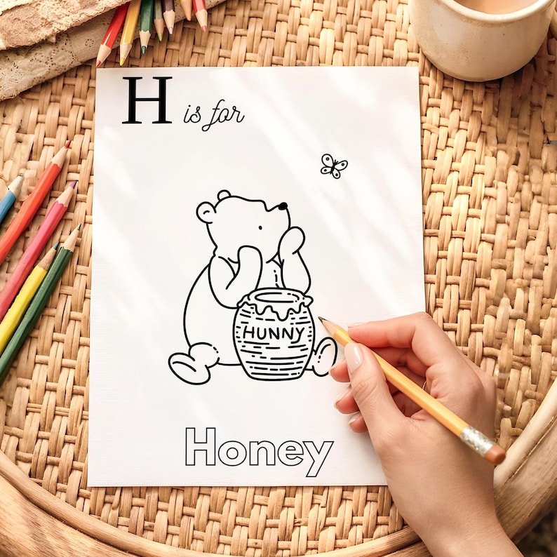 May include: Black and white illustration of Winnie the Pooh with a honey pot labeled "Hunny". The image is part of an alphabet series, with the letter "H" and the word "Honey" displayed. A butterfly is also present.