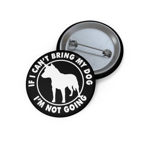 May include: A black button with the text "IF I CAN'T BRING MY DOG I'M NOT GOING" encircling a white silhouette of a dog. A second button is visible in the background.