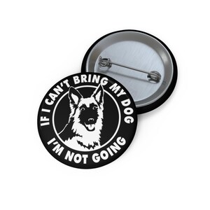 May include: A black and white button with the text "If I can't bring my dog I'm not going" encircling a graphic of a dog's face. The button has a metal pin back.