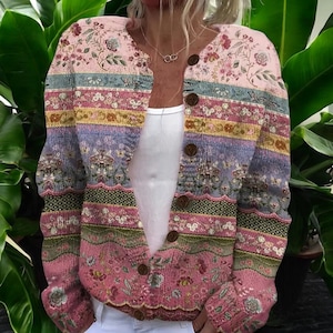 May include: A multi-coloured button-down cardigan featuring floral and striped patterns in pink, blue, green, and yellow. The V-neck cardigan has brown buttons. The floral design is repeated throughout the garment.