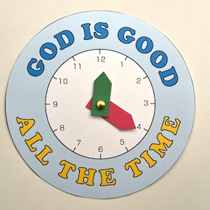 May include: A blue and white clock with the words "God is Good All the Time" printed around the edge. The clock hands are set to 3:00.