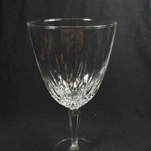May include: A clear glass wine glass with a diamond-shaped pattern on the bowl and a long stem.
