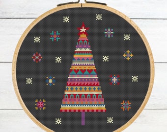 Peut inclure: Un motif de point de croix représentant un sapin de Noël géométrique et coloré sur un fond noir avec des flocons de neige blancs. L'arbre est composé de différentes couleurs, notamment le rouge, l'orange, le jaune, le vert, le bleu, le violet et le rose.