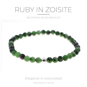 May include: A bracelet featuring green and ruby-coloured beads. The text "RUBY IN ZOISITE" and "925 STERLING SILVER BRACELET" are at the top. The text "Elegance in every bead!" and "HAND MADE IN CANADA" are at the bottom.