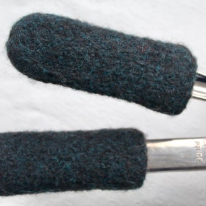 May include: Two gray felt pot holders are attached to the handles of a silver cooking pan. The pan has the text "Chef's Pride" printed on the handle.