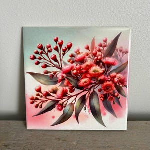 May include: A square ceramic tile featuring a watercolour painting of a bouquet of pink and red flowers with green leaves. The background is a light blue and pink watercolour wash.