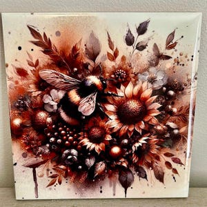 Può includere: Piastrella quadrata in ceramica con un'illustrazione dettagliata di un calabrone tra girasoli ed elementi floreali nei toni del marrone, rosso e crema. L'opera d'arte ha un effetto acquerello, con finitura lucida.