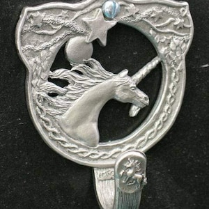 May include: A silver unicorn wall hook with a Celtic knot design. The unicorn is surrounded by a star and a moon. The hook is attached to a silver base with a Celtic knot design.