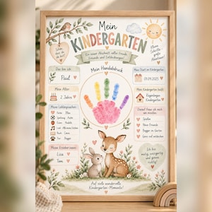以下が含まれることがあります： Mein Kindergartenというタイトルの額入りポスター。中央にカラフルな手形、鹿とウサギのイラスト、名前、年齢、好きなもの、先生の名前などの個人情報を記入するセクションがあり、明るい木製のフレームに入っています。