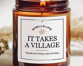 May include: A brown glass candle with a white label that reads "WAX AMORE SMELLS LIKE IT TAKES A VILLAGE Thanks for being a part of mine hand poured with love".
