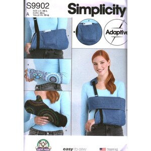 May include: Simplicity sewing pattern S9902 for adaptive arm slings. The pattern includes instructions for a blue denim sling with a pocket, a blue and white patterned sleeve, and a black sleeve with a colourful circular mandala-style print design.
