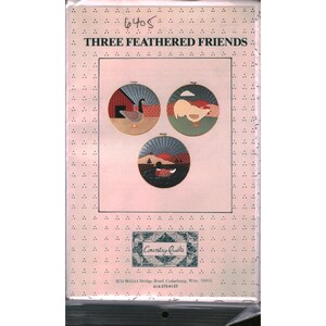 May include: A craft project package titled "Three Feathered Friends." The design features three circular images of birds in a rustic setting. The package includes the text "Country Quilts" and contact information.