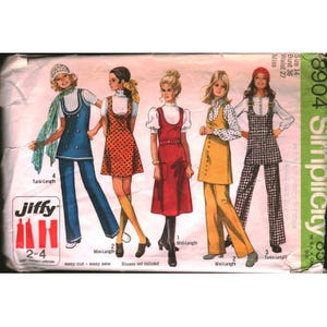 May include: A Simplicity 8904 sewing pattern envelope featuring illustrations of five different outfits including tunics, dresses, and pants. The text includes Jiffy, 2 or 4 main pattern pieces, size 14, bust 36, and waist 27. The designs show various lengths and patterns.