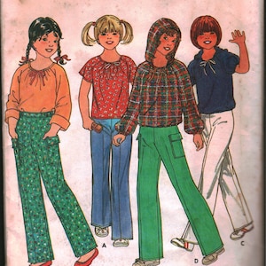 Puede incluir: Un patrón de costura para tres atuendos diferentes para niños. El patrón incluye una blusa de manga larga con un lazo en el cuello, una camisa a cuadros con capucha y una blusa de manga larga con un lazo en el cuello. El patrón es para la talla 7.