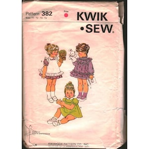 May include: Vintage Kwik Sew pattern envelope featuring illustrations of three young girls in dresses. The envelope is pink with the text "KWIK SEW" and "Pattern 382". The illustrations show the girls wearing different dresses.