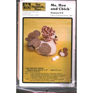 May include: A sewing pattern titled Ms. Hen and Chick Pattern N-9 by Nancy Southerland-Holmes. The cover features a fabric hen wearing a bonnet, a small chick, and two white eggs. Text includes materials needed and finished sizes of 33 cm by 38 cm for the hen and 14 cm by 15 cm for the chick.