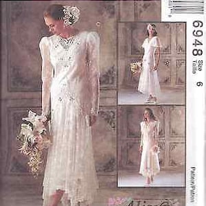 May include: A McCall's sewing pattern for a wedding dress. The pattern is for size 6 and is called "Alice in Wonderland". The pattern shows a white lace dress with a long sleeve and a high neckline. The dress has a fitted bodice and a flowing skirt.