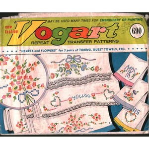 May include: A vintage Vogart repeat transfer pattern envelope, number 690, featuring "Hearts and Flowers" designs for embroidery or painting. The packaging displays illustrations of floral motifs, lace borders, and towels with the text "MRS" and "yours".