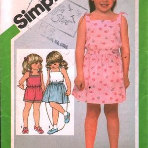 May include: Simplicity pattern 5121 for children's dresses, sizes 5 & 6. The cover features a young girl in a pink dress with heart-shaped patterns. The pattern includes illustrations of different dress styles.