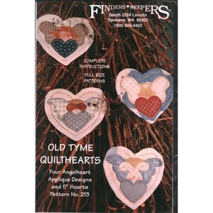Puede incluir: Un patrón para diseños de apliques "Old Tyme Quilthearts". La portada presenta cuatro diseños en forma de corazón con alas de ángel, cada uno de aproximadamente 13 cm. Los diseños utilizan varias telas en tonos de azul, rojo y beige. El texto incluye "Instrucciones completas" y "Patrones de tamaño completo".