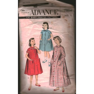 May include: An Advance 7804 sewing pattern envelope for size 12, featuring illustrations of three different dress styles. One dress is solid blue, one is red with white polka dots, and the third is a long-sleeved plaid dress with a button-front design.