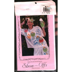 May include: A packet of Show-Offs painter friendly press-on patterns featuring hot air balloon designs. The packaging displays a white shirt and matching bottoms decorated with colourful hot air balloons, clouds, and a matching hat and shoe accent.