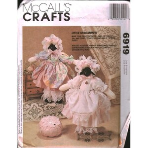 May include: McCall's Crafts 6919 sewing pattern envelope for Little Miss Muffet storybook lambs. The pattern includes instructions to create two stuffed lamb dolls, 16 inches tall, wearing floral and pink dresses with bonnets, and a 5 inch tuffet.
