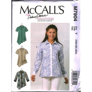 May include: McCall's M7904 sewing pattern envelope featuring illustrations of three shirt variations labeled A, B, and C, and a photograph of a long-sleeve button-down shirt labeled D with a blue and white striped pattern and white floral overlay.