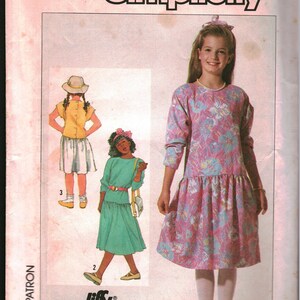 May include: Simplicity sewing pattern for a girl's dress. The pattern includes three different styles: a long-sleeved dress with a floral print, a short-sleeved dress with a solid color, and a skirt with a yellow top. The pattern is for size 8.