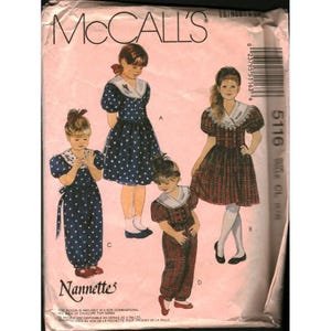 Puede incluir: Sobre de patrón de costura McCall's con cuatro diseños de vestidos infantiles. Los vestidos incluyen un vestido de lunares, un vestido a cuadros y un mono. El sobre tiene el texto "Nannette" y el número de patrón 5116.