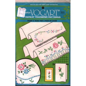 May include: A Vogart repeat transfer pattern packet, number 702, featuring roses and buds for three pairs of cases. The packaging displays illustrations of embroidered floral designs on white fabric, including lace-edged linens and a single rose motif.