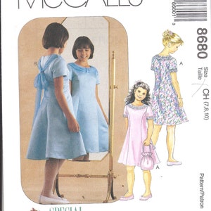 May include: A sewing pattern for a girl's dress. The pattern is for sizes 7, 8, and 10. The pattern is called "Special Moments" and is from McCall's.
