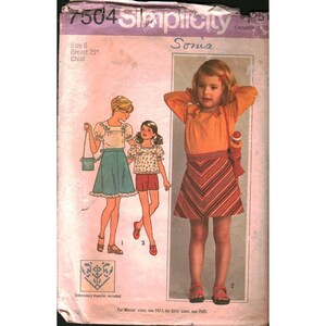 May include: A Simplicity 7504 sewing pattern envelope for a child's size 6, 63.5 cm breast garment. The cover features illustrations of three children wearing various outfits, including a skirt, blouse, and shorts, with an embroidery transfer included.