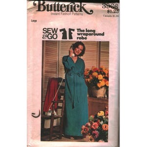 Puede incluir: Sobre de patrón de costura Butterick 3966 para una bata larga cruzada en talla Large. La portada incluye el texto Sew & Go, The long wraparound robe y Butterick Instant Fashion Patterns. Se muestra una bata de color verde azulado en la portada.