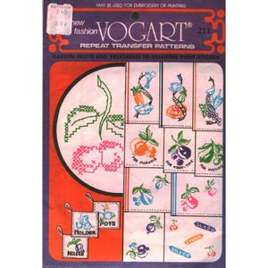 May include: A Vogart repeat transfer pattern packet, number 211, featuring garden fruits and vegetables for embroidery or painting. The purple and orange packaging displays various cross-stitch designs, including kitchen motifs, fruits, and text labels.