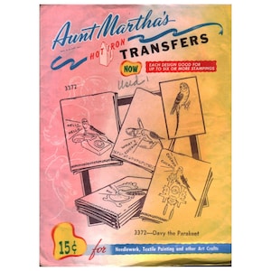 May include: A vintage Aunt Martha's Hot Iron Transfers packet, number 3372, titled Davy the Parakeet. The cover features illustrations of parakeets with text including Hello Hello, What's Cookin, and Cuckoo Cuckoo. The background is a gradient of pink and yellow.