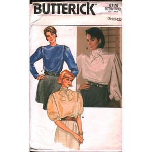 May include: A vintage Butterick sewing pattern featuring three blouse designs. The pattern cover displays illustrations of the blouses in various colors and styles, including a blue long-sleeved blouse, a white blouse with a necktie, and a beige blouse with a bow.