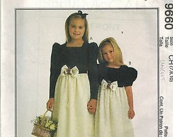 May include: A sewing pattern for two girls' dresses. The pattern is for sizes 7, 8, and 10. The dresses are white with black sashes and bows. The pattern is called "Salome by Jolene".