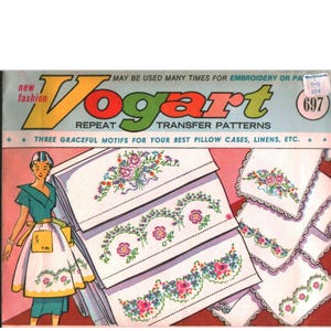 May include: A vintage Vogart repeat transfer patterns envelope featuring a graphic of a person in a green dress and white apron. The packaging displays floral embroidery designs on white fabric swatches with pink and blue accents, labeled 697.