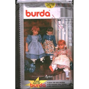 May include: A Burda sewing pattern for doll clothes, showing three dolls in different outfits. The dolls wear dresses and aprons. The Burda logo and pattern number 3678 are displayed on the packaging.
