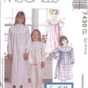 May include: A sewing pattern for a nightgown and pajamas for girls. The pattern is from McCall's and is for sizes 10, 12, and 14. The pattern includes a long-sleeved nightgown with a ruffled collar and a long-sleeved pajama top and pants.