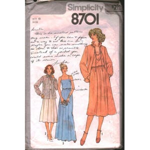 Puede incluir: Un sobre de patrón de costura Simplicity 8701 para ropa de mujer. El frente presenta ilustraciones de tres conjuntos: una blusa estampada con falda, un vestido azul sin mangas y un vestido color melocotón con mangas largas y cuello alto.