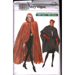 May include: A Very Vogue sewing pattern showing two cape designs. One cape is rust-coloured with a hood, and the other is black. The pattern includes the text "VERY EASY / TRÈS FACILE" and size L-XL.