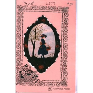May include: A pink card with a black and white illustration of a woman in a dress and hat carrying a basket. The illustration is framed by a black oval and surrounded by floral and scroll designs. The number "6377" is in the upper left corner.