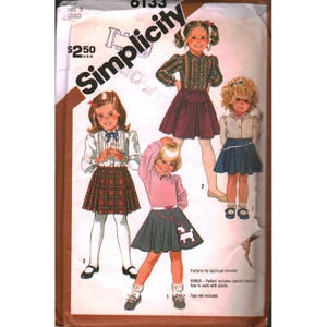 Könnte beinhalten: Simplicity Schnittmuster für Kinderkleidung, Größe 5. Das Schnittmuster enthält Designs für Röcke und Oberteile, mit einem Bonusabschnitt zum Arbeiten mit Karos. Das Cover zeigt Illustrationen der fertigen Kleidungsstücke.