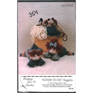 May include: A craft pattern titled "NOTHIN' TO DO" featuring two rag dolls, Ann and Andy, and a small cat doll. The dolls have red yarn hair, fabric bodies, and button eyes. The pattern includes instructions for making 7-inch Ann, 5-inch Andy, and a kitty.